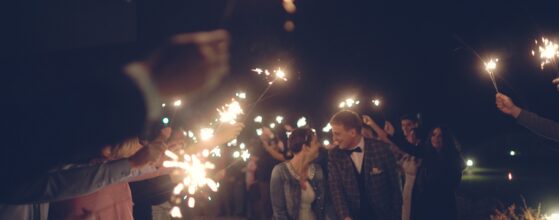 Bius és Csabi az esküvői vendégek között éjszakában a Kreinbacher birtok udvarán, világítóanyagok és fények körülötte