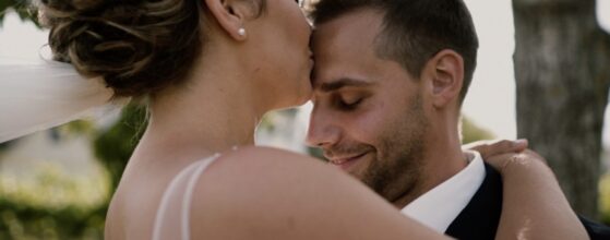 Anna küsst Anton auf die Stirn zwischen den Reben beim Weingut Dworzak in Deinzendorf – ein warmer Moment ihres Hochzeitsfilms mit einem niederländischen Hochzeitsvideografen.