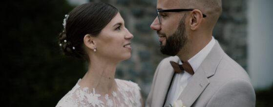 Kata és Gábor egymás felé fordulva állnak a zalacsányi Batthyány Kastélyszálló parkjában, elegáns nyári esküvői pillanat az esküvői filmjükből.