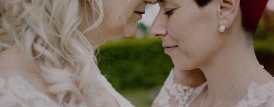 ornelia und Venere legen die Stirn aneinander und schließen die Augen im Garten von Schloss Obermayerhofen – ein ganz leiser, emotionaler Moment ihres Hochzeitsfilms.