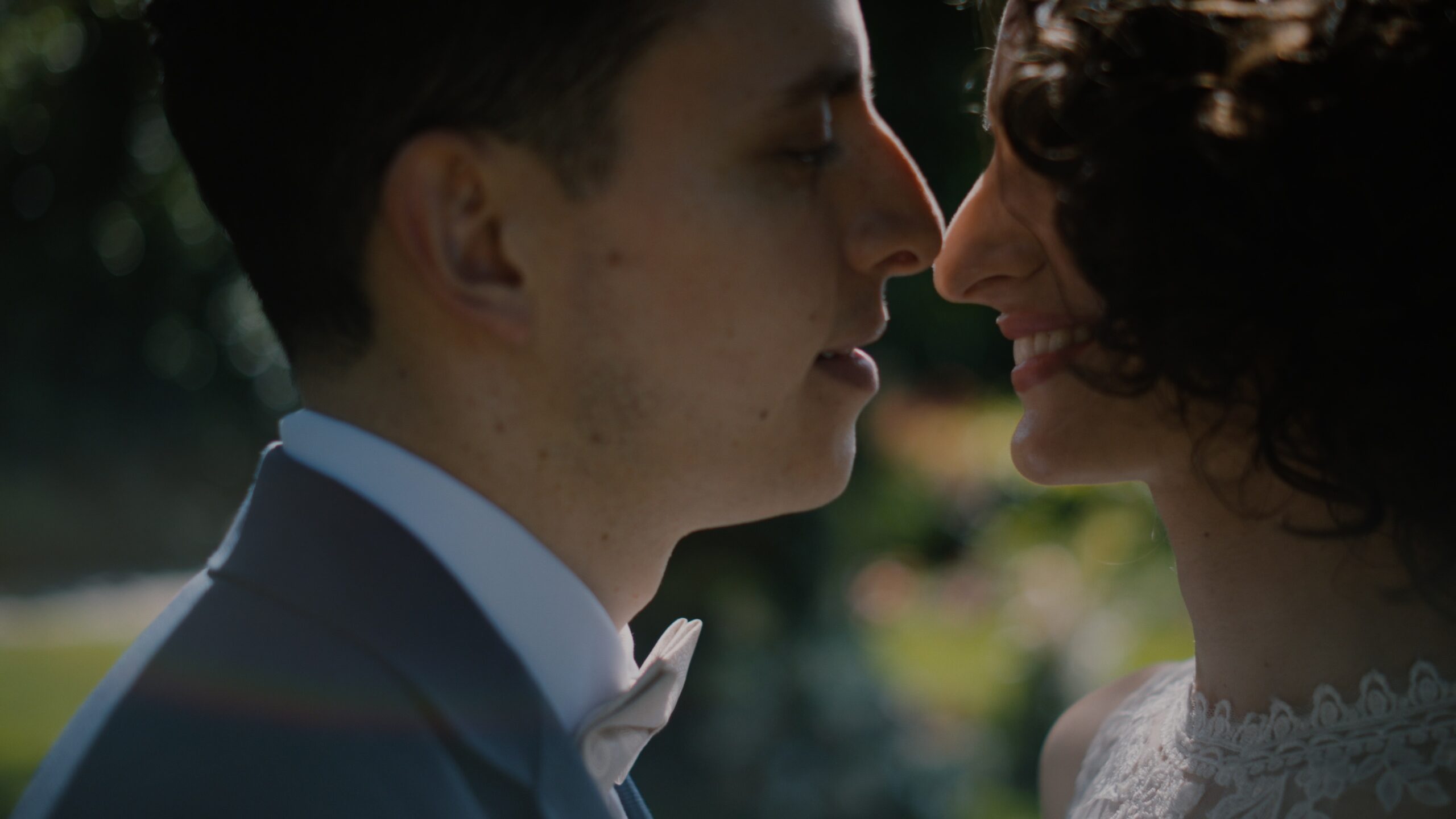 Close-up of Noémi and Juan Martin facing each other in the garden of Tópart Hotel in Balatonvilágos during their wedding day – detail from their wedding film. Balaton wedding videographer