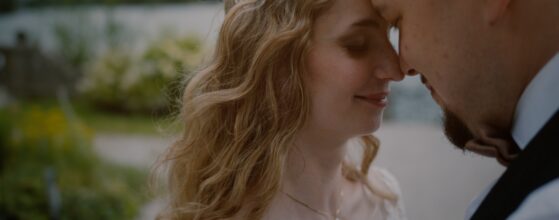 Braut und Bräutigam lehnen die Stirn aneinander am See von Schloss Leopoldskron in Salzburg – romantischer Moment aus ihrem Hochzeitsfilm.