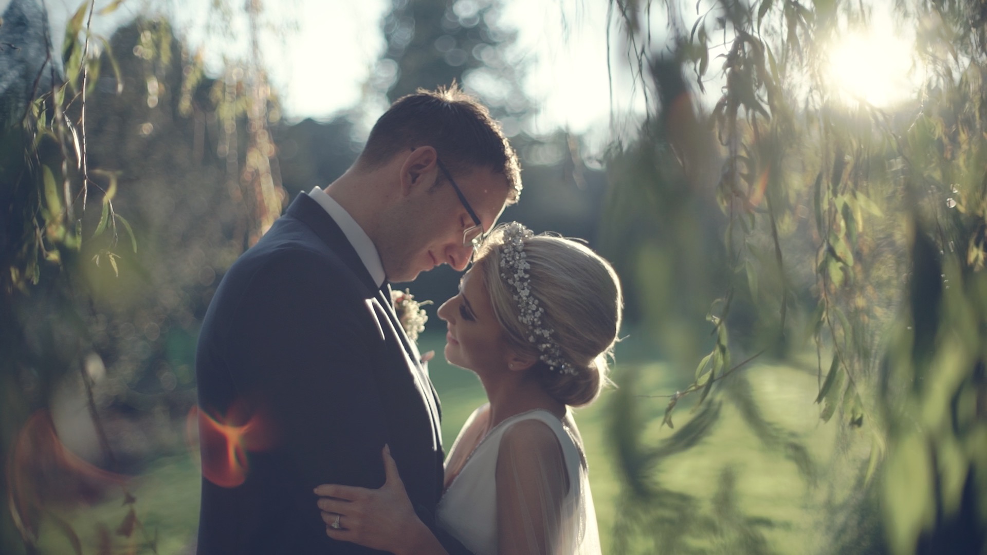 Caoimhe and Michael sharing a quiet moment under the trees at Castle Leslie Estate in Ireland, with soft afternoon light and a romantic wedding film atmosphere.