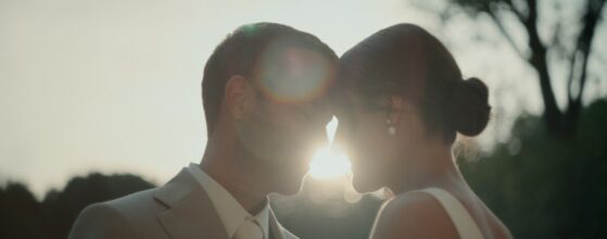 Christina und Dennis im Gegenlicht während ihres First‑Look‑Moments im Garten von Lorenz Wachau in Niederösterreich, eingefangen vom hochzeitsvideografen.