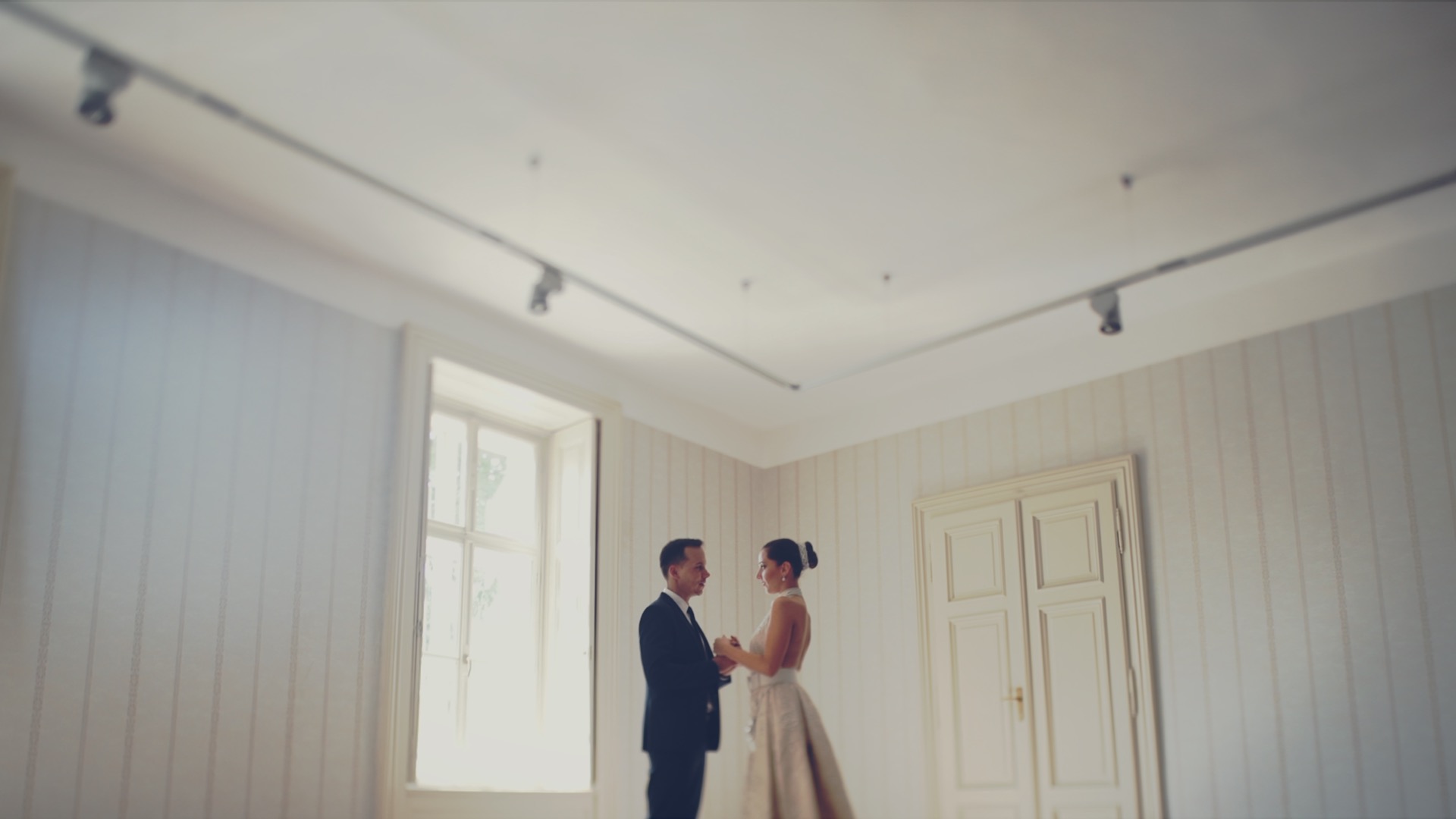 Dalma és Norbi egymással szemben állnak a világos, elegáns szobában a Degenfeld-Schonburg kastélyban, a nagy ablak mellett Degenfeld kastély esküvő