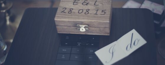 Wooden ring box with Em and Liam’s wedding date and a small card saying I do at Old Swan and Minster Mill, a soft, intimate wedding detail from their film in England.