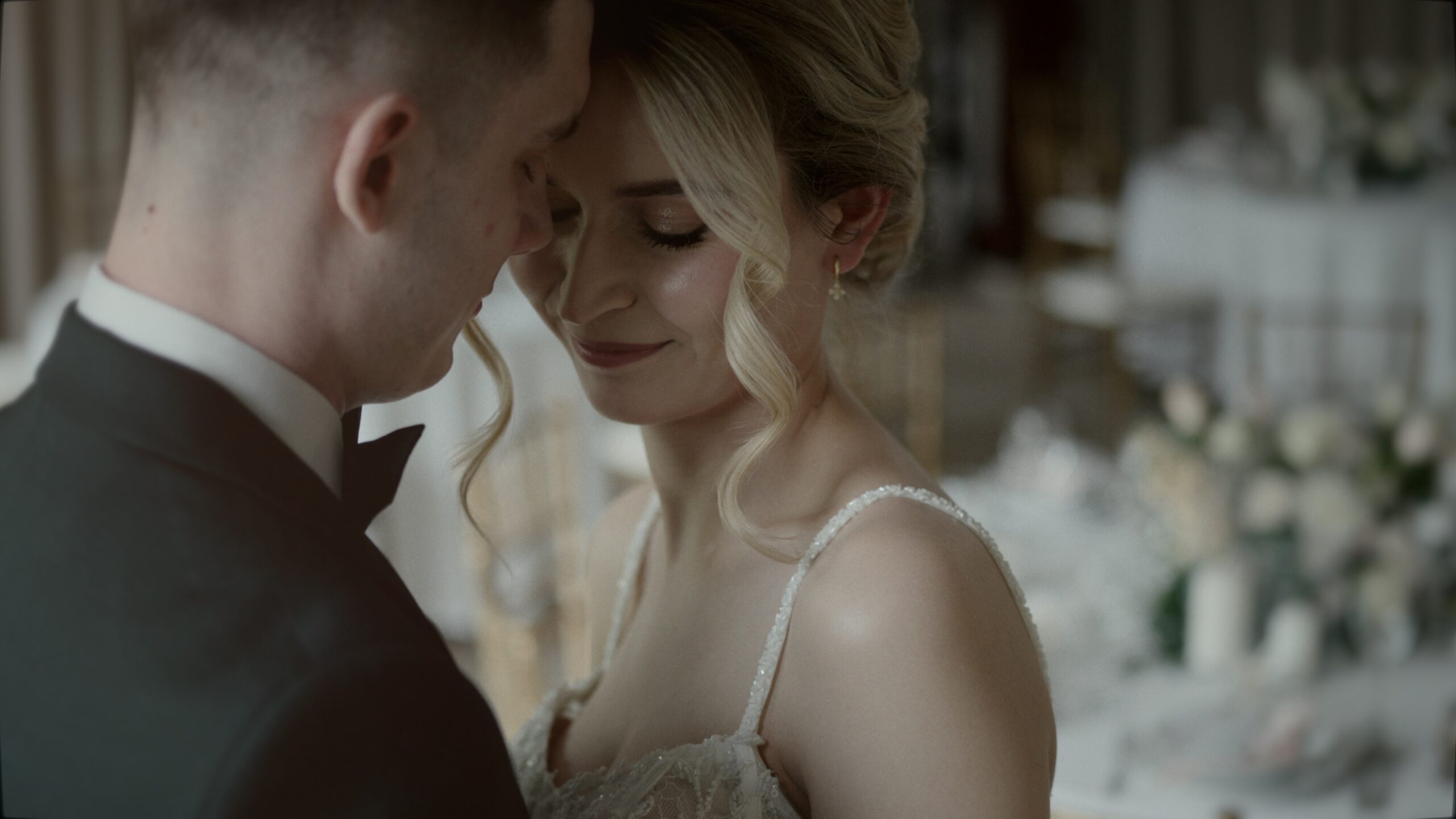 Enci és Tomaj szoros ölelésben táncolnak a Nádas Pihenőpark benti termében, intim pillanat az esküvői filmből.