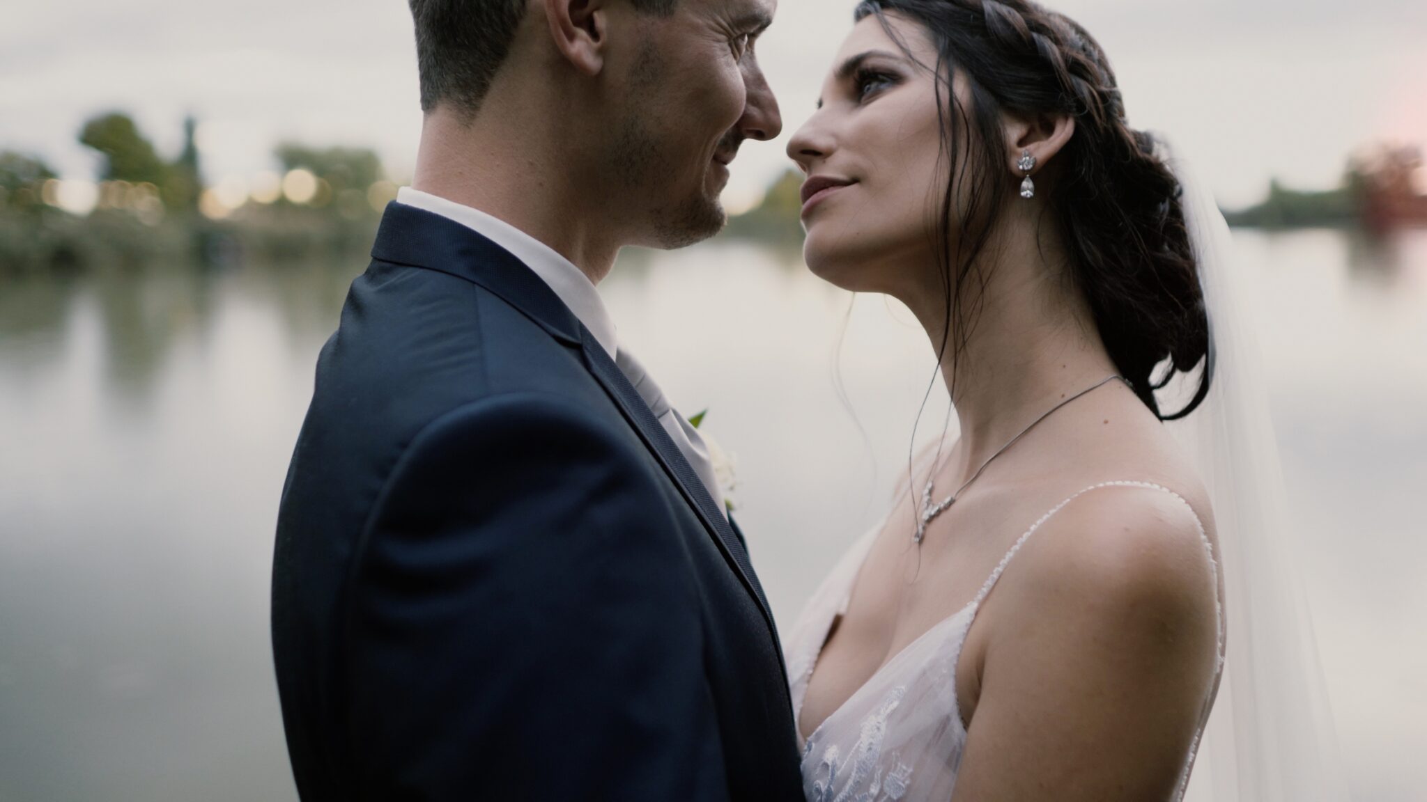 Eszter és Péter szorosan egymáshoz bújva állnak a tóparton a sárvári Park Inn by Radisson mellett – egy meghitt pillanat az esküvői filmből, Eszter Percek Tik-Tok esküvői film Sárvár