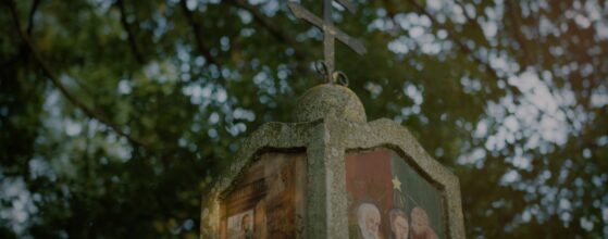 Stone cross with religious painting in the garden of Vedahof in Gramastetten – atmospheric detail from Gloria and Rudolf’s wedding teaser.