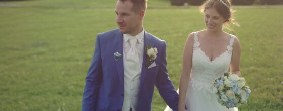 Isabella und Paul gehen Hand in Hand über die Wiese beim Berghotel Tulbingerkogel mit Blick auf die umliegenden Hügel bei ihrer Hochzeit