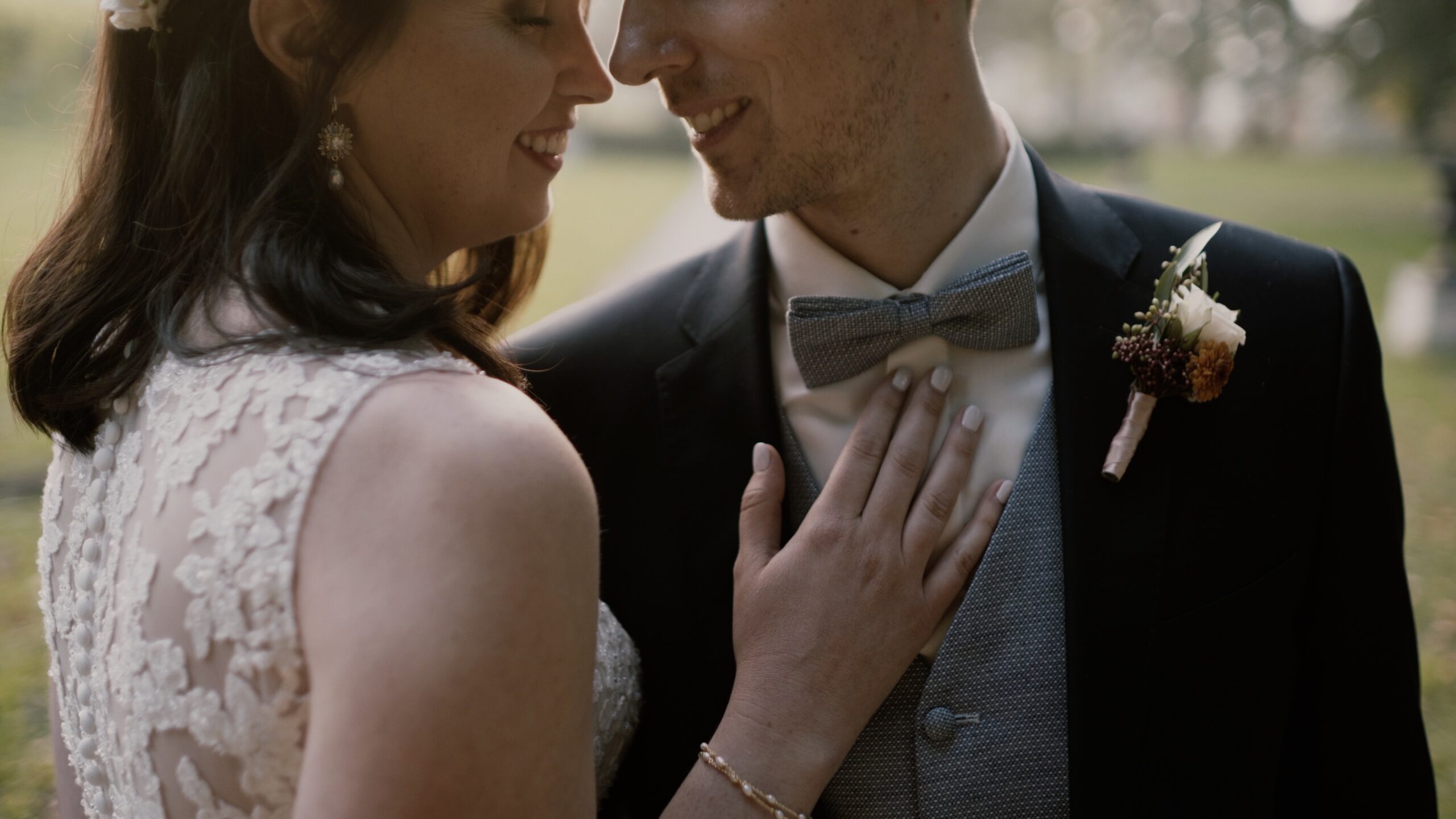 Kara legt ihre Hand auf Philips Brust, während sie sich im Park von Schloss Obermayerhofen anlächeln – intimer Moment ihres Hochzeitsfilms in der Steiermark.
