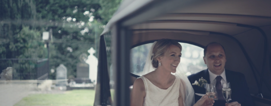 Kate and Conan sharing a quiet champagne moment in their wedding car outside the church in Donegal, Ireland, a soft, intimate scene from their Lough Eske Castle wedding film.