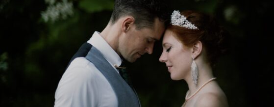 Lana und David legen die Stirn aneinander im Garten von Schloss Obermayerhofen in Österreich – ein ruhiger, emotionaler Moment aus ihrem Destination Hochzeitsfilm. Austria destination wedding cinematographer