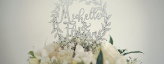 Richardhof Gumpoldskirchen hochzeit videograf Weißer Brautstrauß mit grünen Blättern vor einer Wanddeko mit "Hello Friends" und Blattmotiven, eine elegante Hochzeitsdekoration.