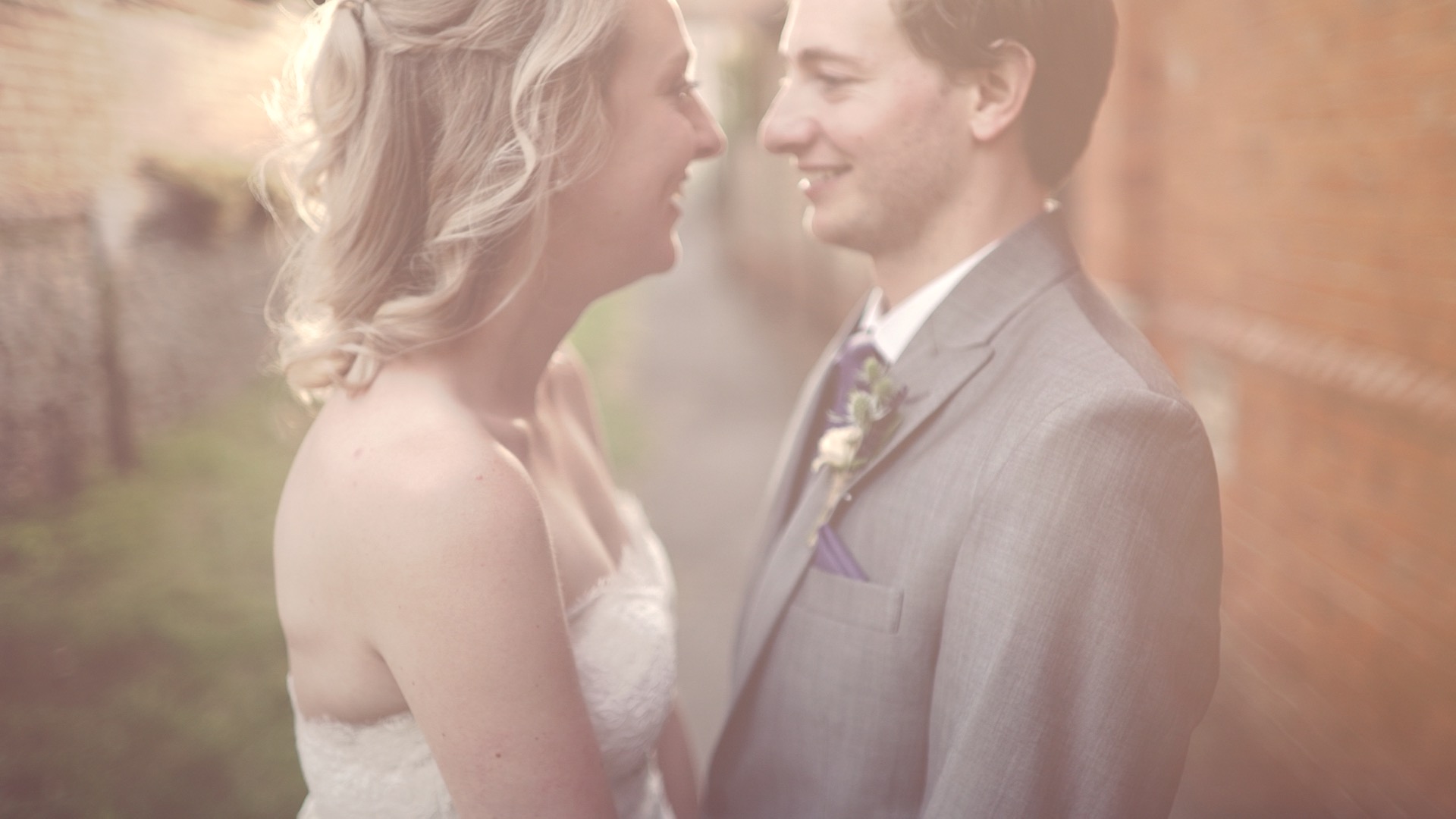 Soft, romantic portrait of Sarah and Peter on their wedding day in Oxfordshire, England, with pastel light and a gentle documentary wedding videography feel.