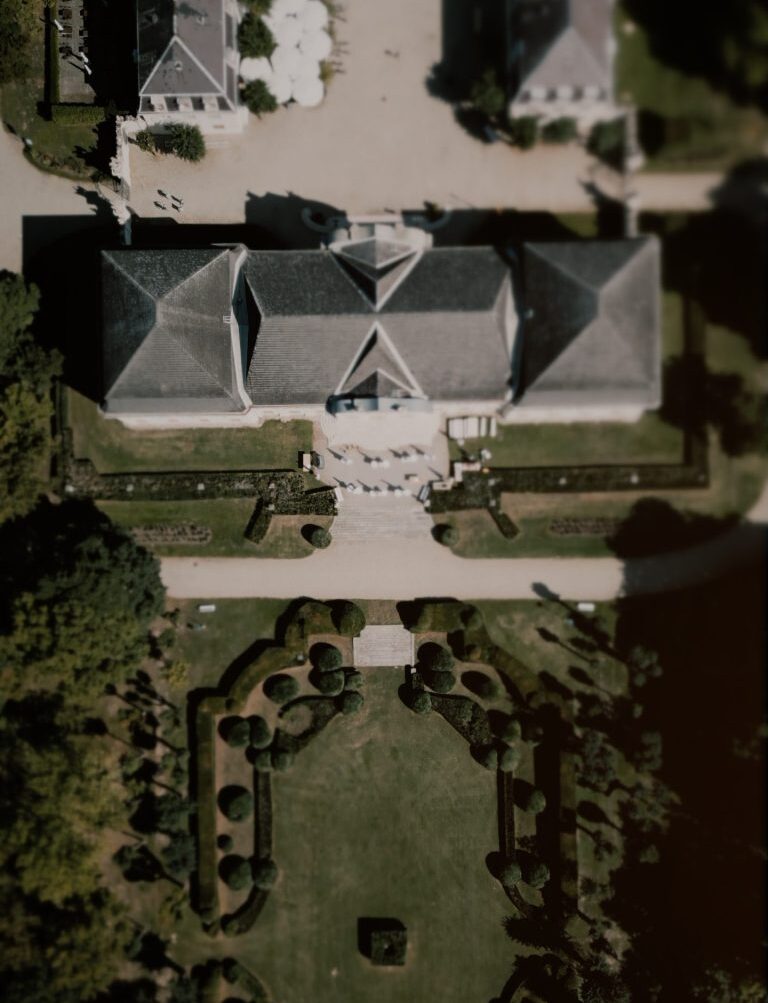 Drohnenaufnahme von Schloss Halbturn im Burgenland mit barockem Schlossgebäude und symmetrisch angelegtem Schlosspark – perfekte Kulisse für elegante Hochzeiten. Schloss Halbturn Hochzeitsvideograf