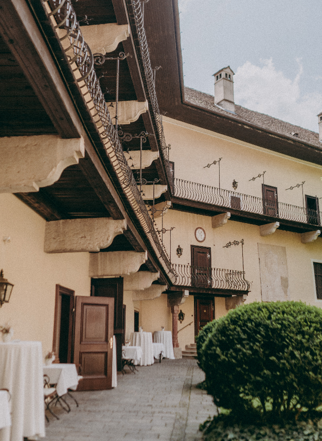Malerischer Arkadenhof im Schloss Obermayerhofen in der steirischen Thermenregion, vorbereitet mit gedeckten Tischen für einen eleganten Sektempfang bei einer Hochzeit. Schloss Obermayerhofen Hochzeit