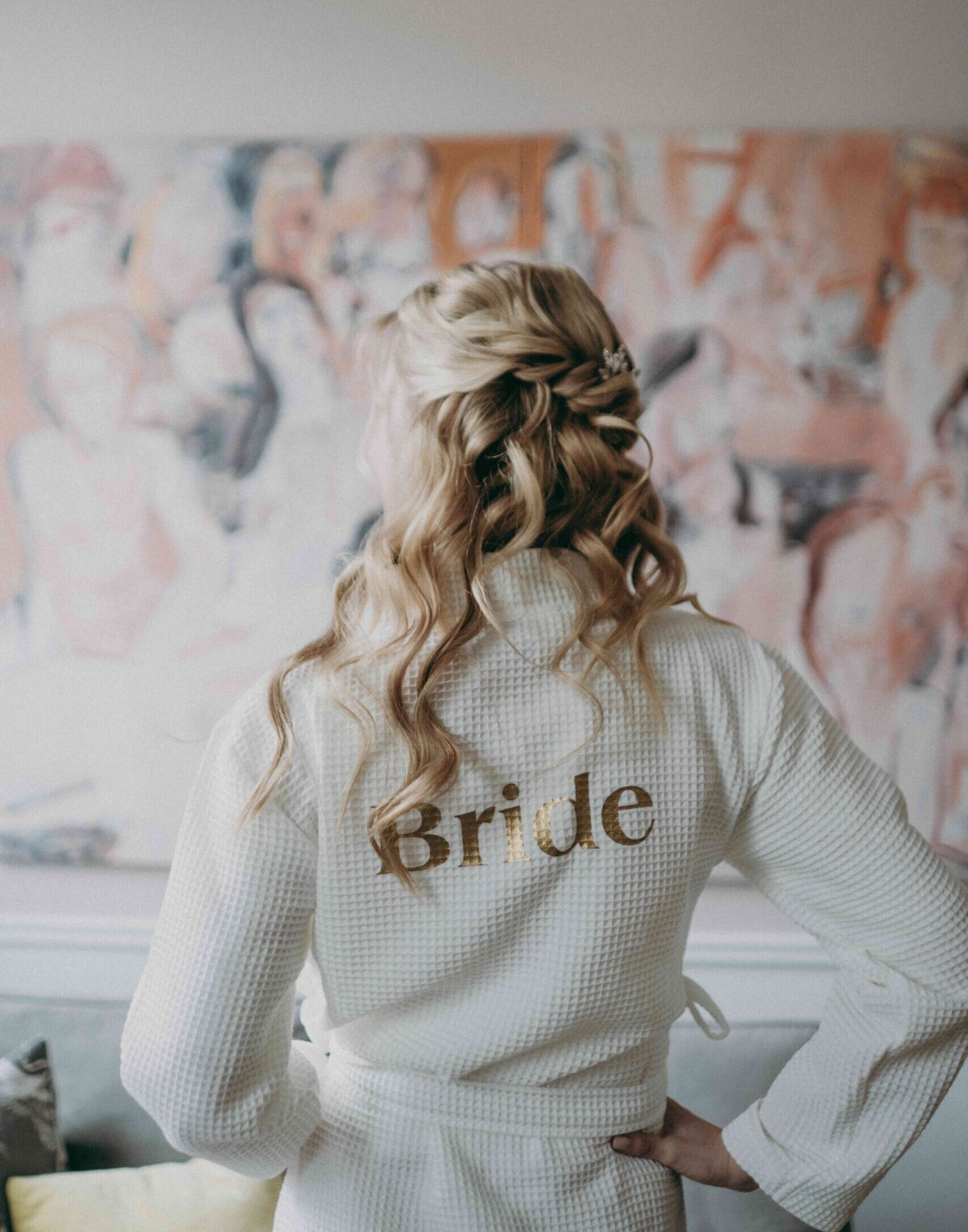 Stephanie trägt einen weißen Bride-Pullover vor dem Pfarrwirt in Wien – ein persönlicher Moment ihrer Hochzeit im Herzen der Stadt.