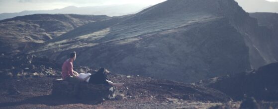 Pregnant Bojana embraces Darko during their maternity couple shoot on Madeira Island, with dramatic volcanic mountains and scenic landscape in the background