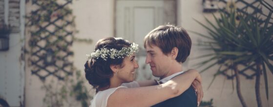 Dan et Jho s'enlacent tendrement lors de leur séance photo de mariage au Domaine de Roquefeuille à Marseille, avec une architecture provençale en arrière-plan