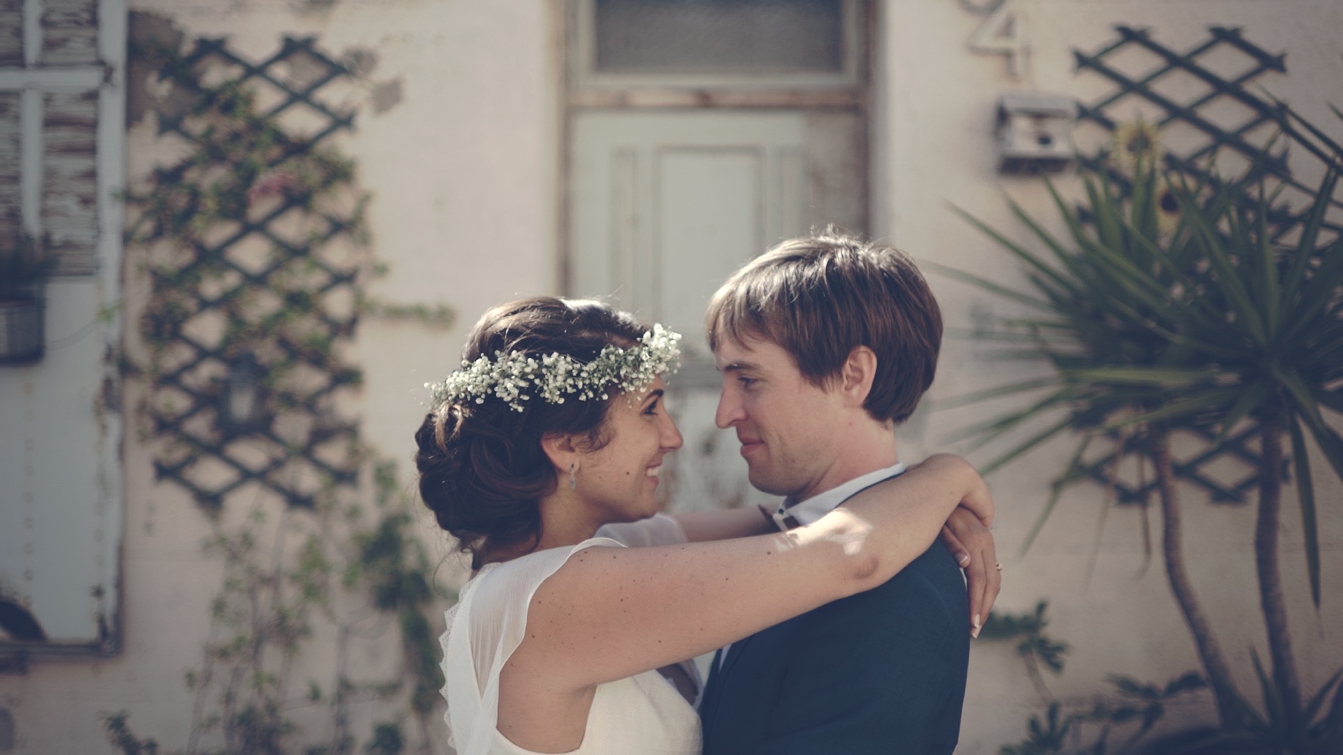 Dan et Jho s'enlacent tendrement lors de leur séance photo de mariage au Domaine de Roquefeuille à Marseille, avec une architecture provençale en arrière-plan