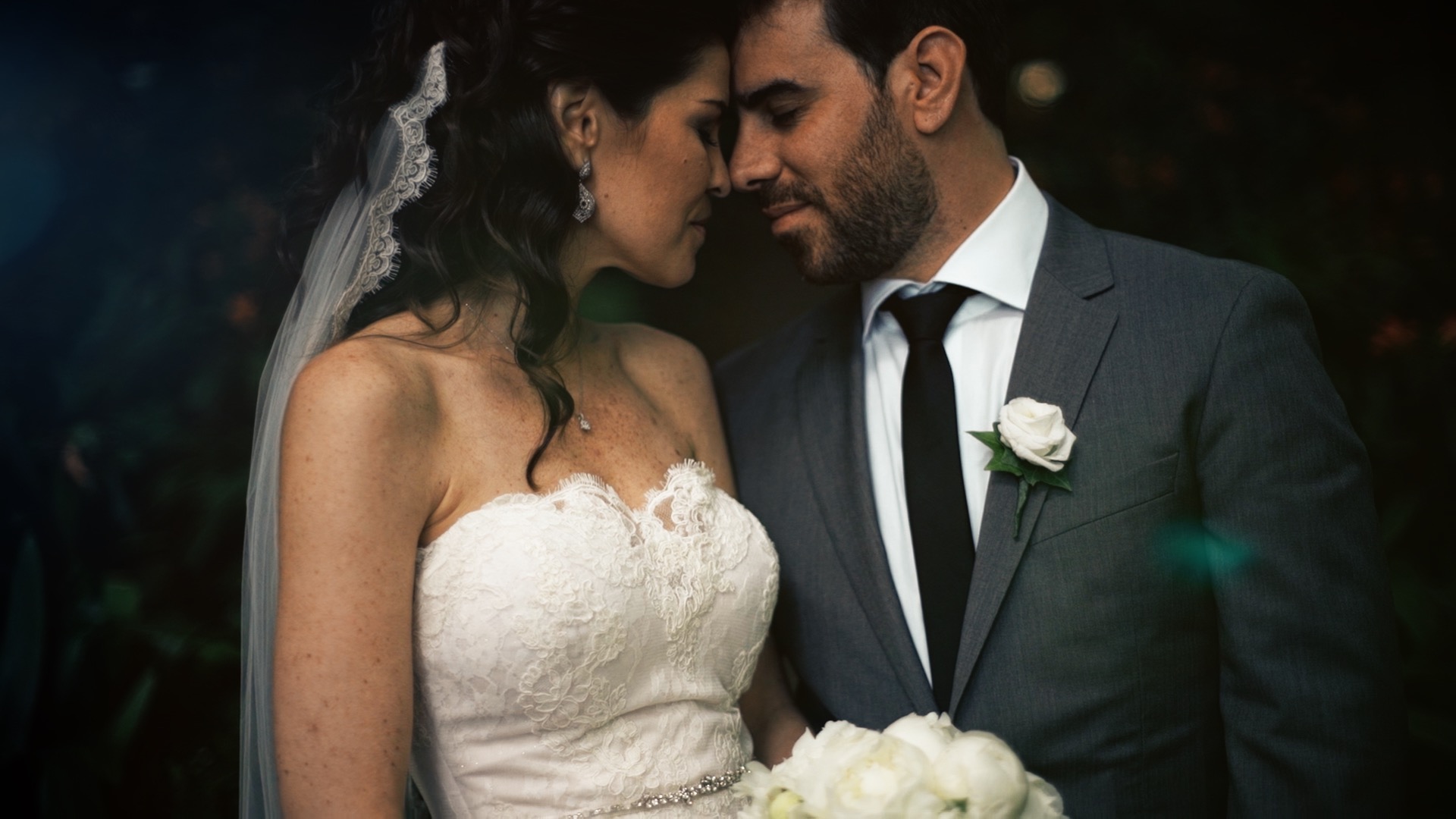 American bride Trisha in white lace wedding dress and Portuguese groom Luis from Madeira in dark suit share an intimate emotional moment during their destination wedding in Madeira, Portugal
